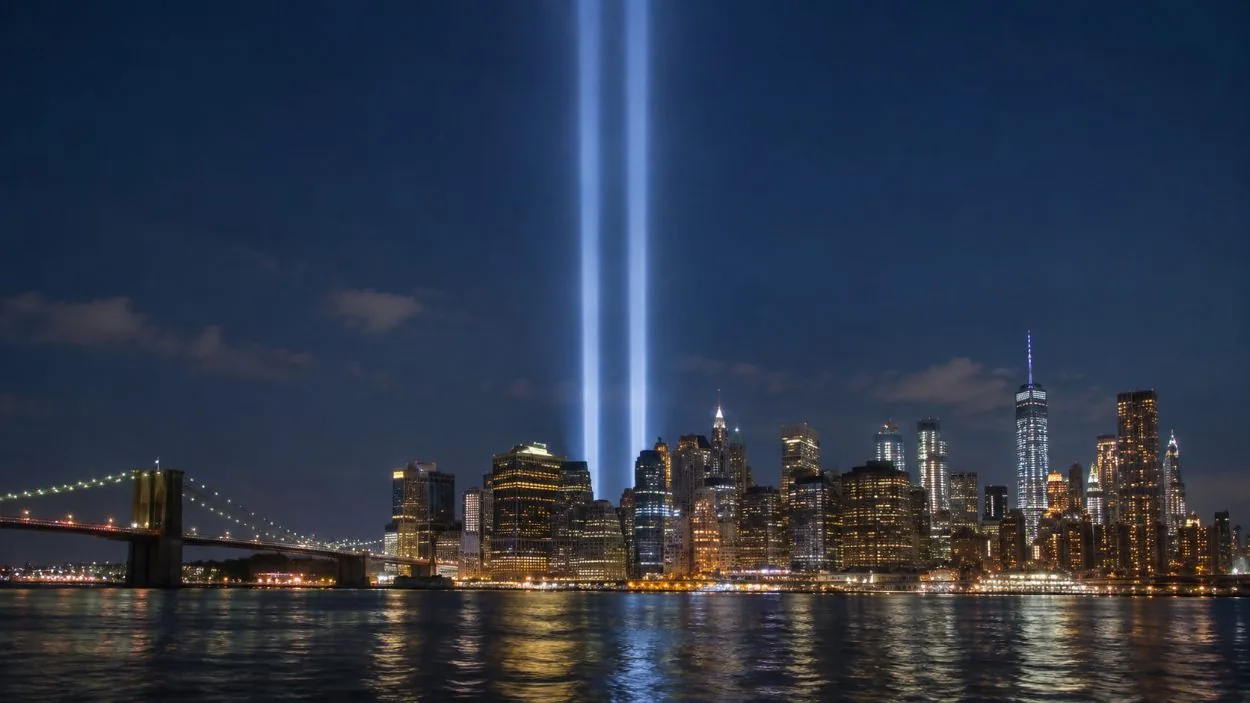 Two columns of light rising into the night sky over Lower Manhattan